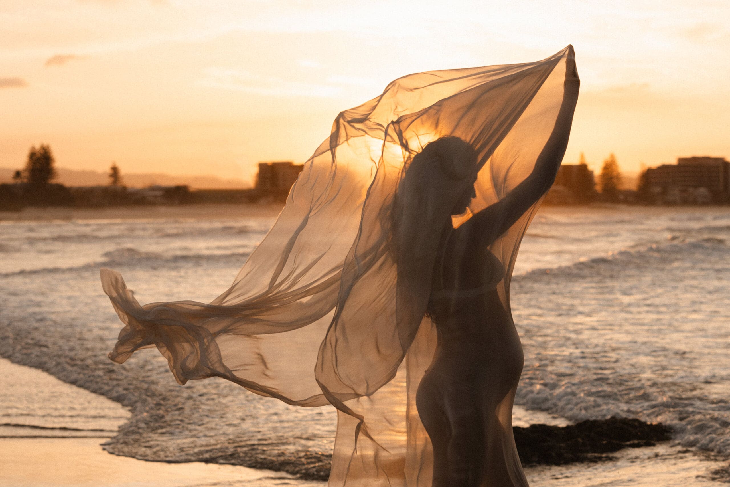 pregnant mother with fabric at sunset